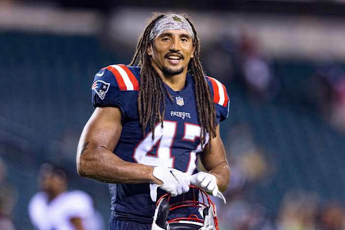 Jakob Johnson smiles while on the field for pre-game warmups